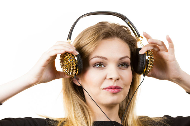 Teenager young grunge woman listening to music on headphones with spikes. Female enjoying her passion. - Zdjęcie, obraz