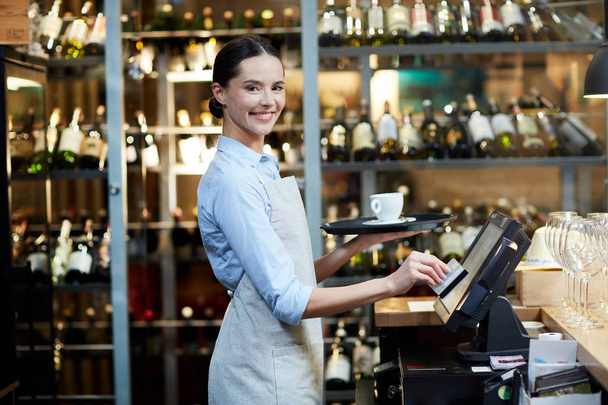 Молодая веселая официантка, регистрирующая заказ и приносящая его клиенту
 - Фото, изображение
