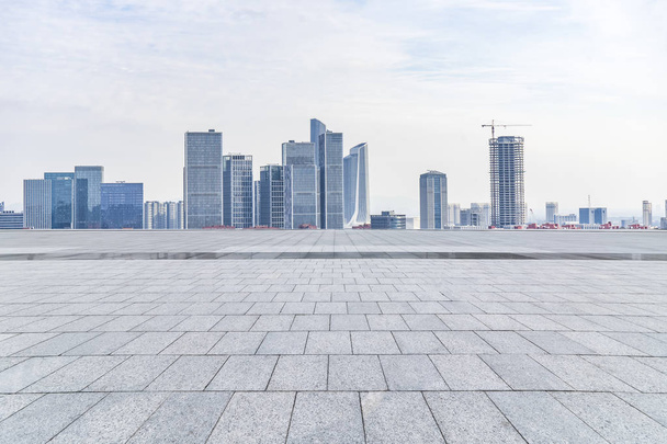 Panoramatické panorama a moderní kancelářské budovy s prázdnou silnicí, prázdné betonové čtvercové podlahy - Fotografie, Obrázek