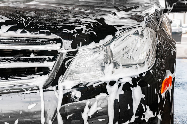 Car washing. Cleaning modern car covered by foam. - Fotografie, Obrázek