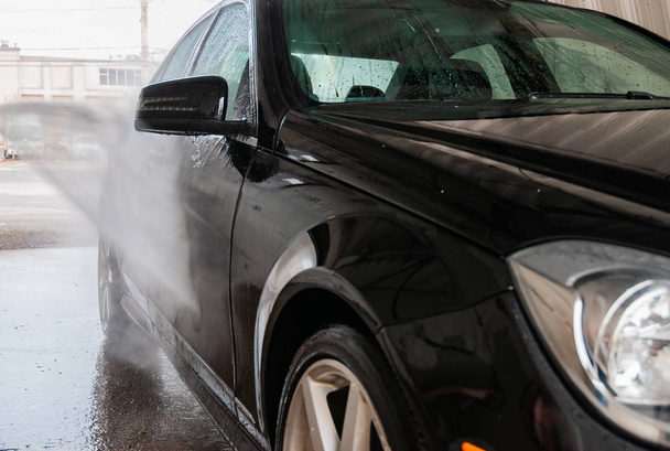 Car washing. Cleaning car using high pressure water. - Photo, Image