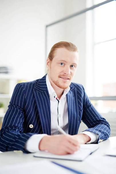 Portrait of redheaded businessman working at office - 写真・画像