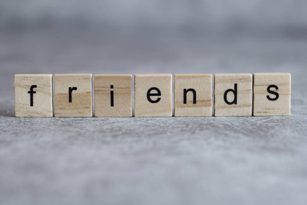 Friends word written on wood cube with gray background. - Photo, Image