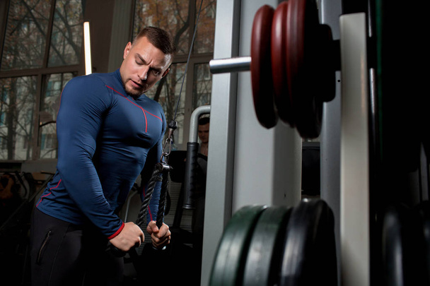 Erős, izmos ember gyakorlása a tornateremben edzés közben sportlétesítmények - Fotó, kép