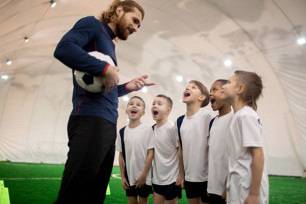 Excited football team of five boys asking their trainer to take them to championship - Photo, Image