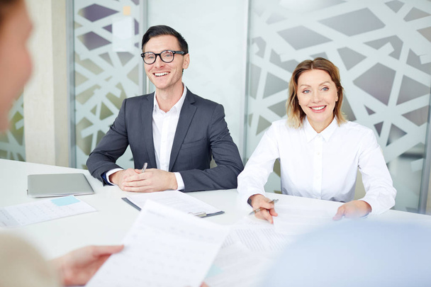 Two confident employers talking to applicants during interview in office - Photo, Image