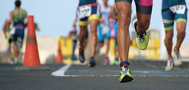 Гонка на марафоне, бегуны на ногах по дороге
 - Фото, изображение