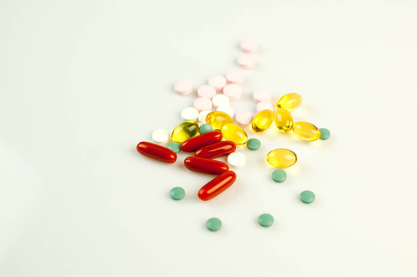Bovenaanzicht van veel kleurrijke pillen liggend op witte achtergrond, geïsoleerd. Geneeskunde Concept. - Foto, afbeelding
