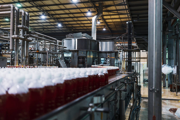 Botellas de soda roja en la línea de fábrica
. - Foto, Imagen
