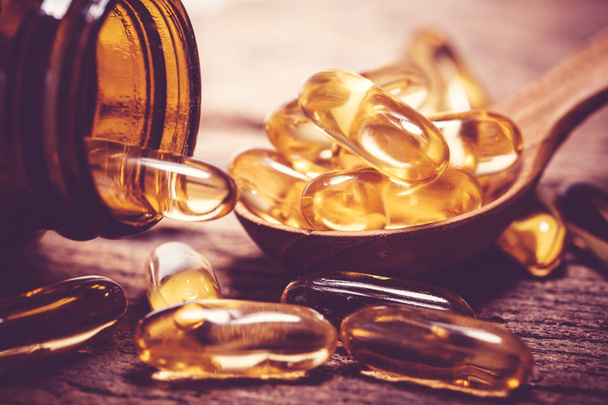 Zblízka vitamin D a Omega 3 kapsle rybího oleje doplněk na dřevěné desce pro dobrý mozek, srdce a zdraví jíst přínos - Fotografie, Obrázek