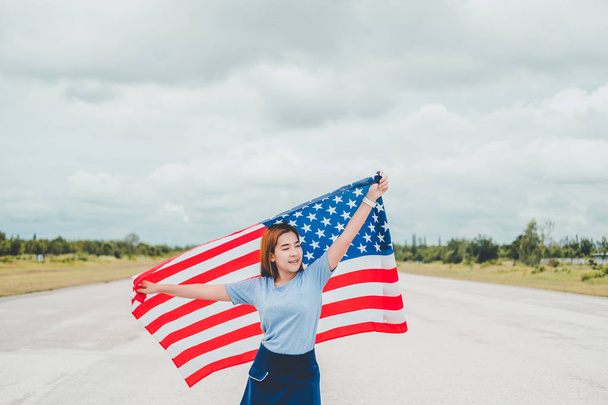 Happy woman standing with American flag Patriotic holiday.USA celebrate 4th of July - Фото, изображение