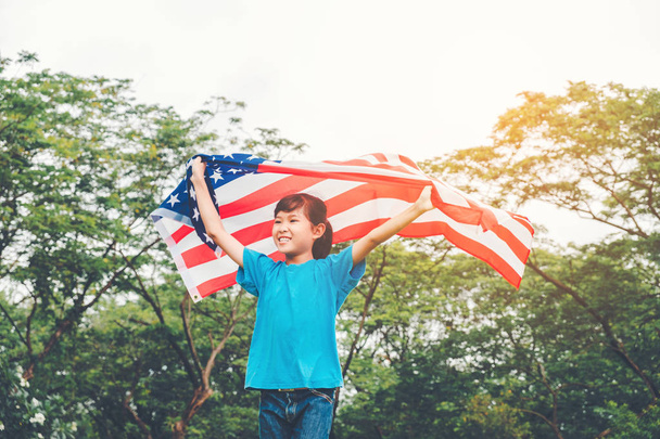 Happy kid little child running with American flag USA celebrate 4th of July - Фото, изображение