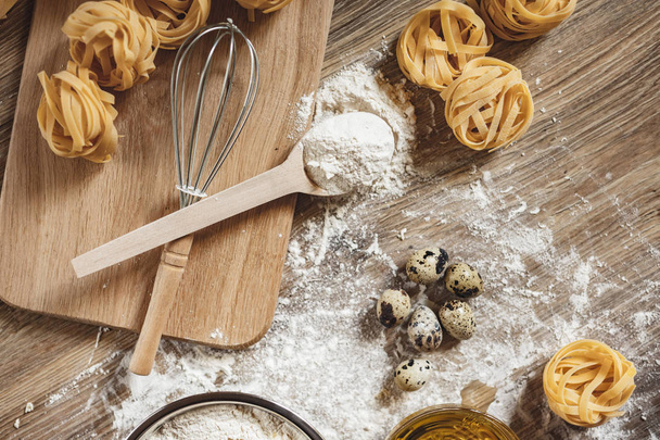 Raw homemade pasta and ingredients for pasta on a wooden background - Φωτογραφία, εικόνα