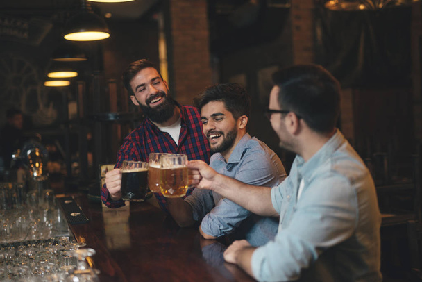 Хлопці в пабі п'ють пиво
 - Фото, зображення