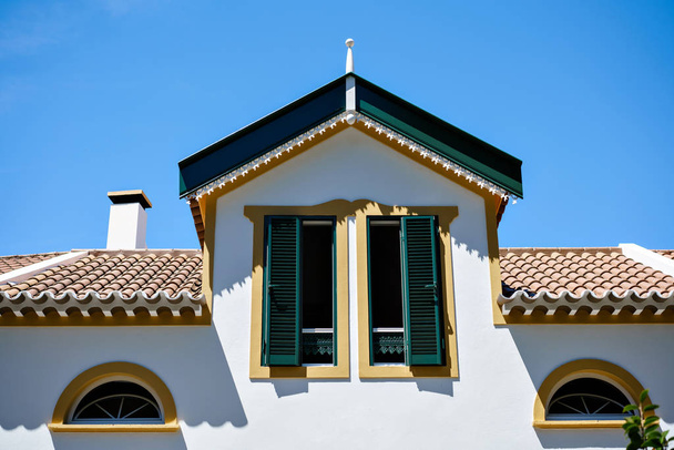 Díszes homlokzat a színes ház Sao Miguel, Azori. Portugália. Gyönyörű régi apró házak, zöld ajtó és ablak redőnyök - Fotó, kép