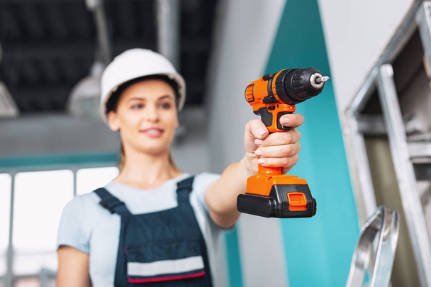Joyful skilled builder holding a drill - Photo, image