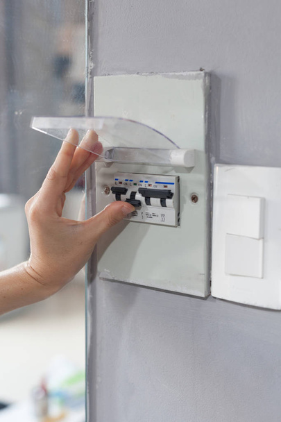 Woman hand  turning off fuse box in the house - Photo, Image