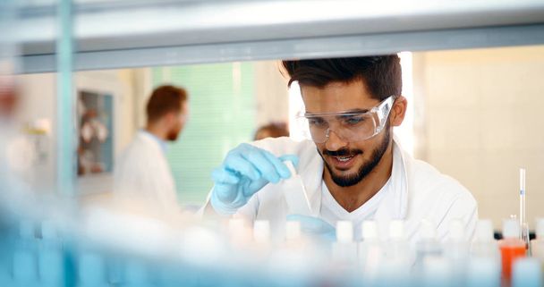 Attractive male student of chemistry working in lab - Foto, Bild