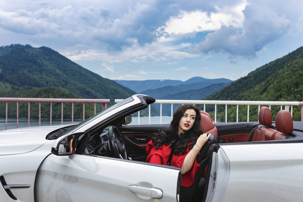 Gyönyörű fiatal nő, egy kabrió autó, élvezi a nyári nap - Fotó, kép