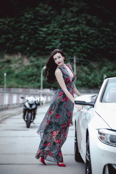 Fashion portrait of young woman in elegant dress outdoor in cabriolet car - Фото, изображение