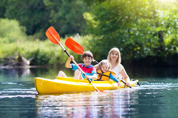 Bambino con pagaia in kayak. Campo estivo per bambini. Kayak e canoa con la famiglia. Bambini in canoa. Famiglia in kayak. Natura selvaggia e divertimento acquatico in vacanza estiva. Campeggio e pesca
. - Foto, immagini