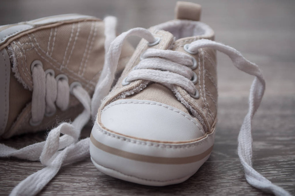 closeup of baby sneakers on the floor - Фото, изображение
