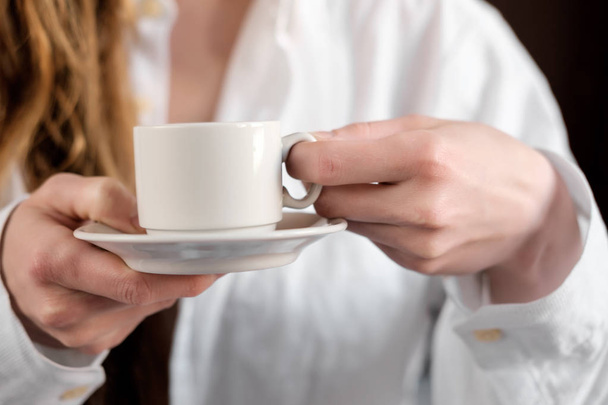 Fehér vöröshajú lány a fehér ing, kávét inni, közelről - Fotó, kép