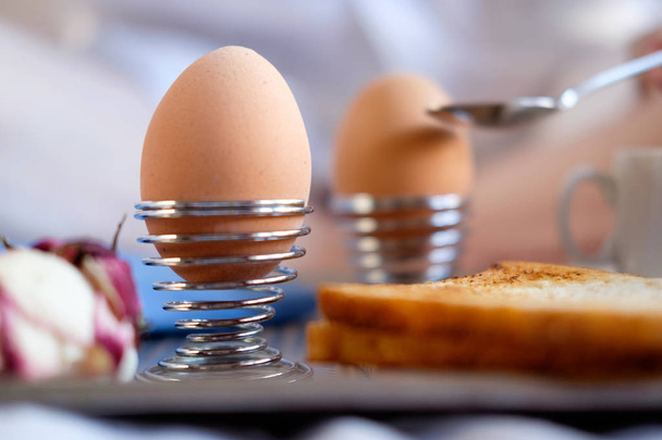 Breakfast in bed in hotel. Boiled eggs with toasts close up. - Photo, Image