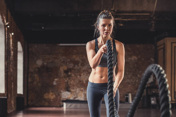 Young girl with a rope on a cross-training indoors - Photo, Image