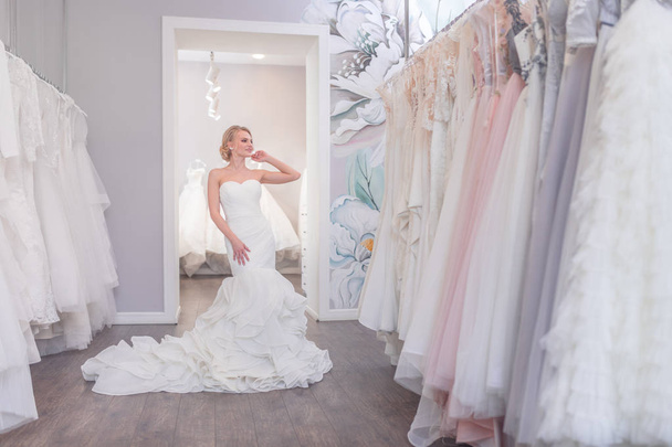 Ελκυστική γυναίκα σε ένα γαμήλιο φόρεμα στο κατάστημα - Φωτογραφία, εικόνα