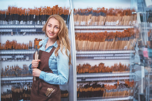 Chica joven con un cepillo en la tienda de arte
 - Foto, Imagen