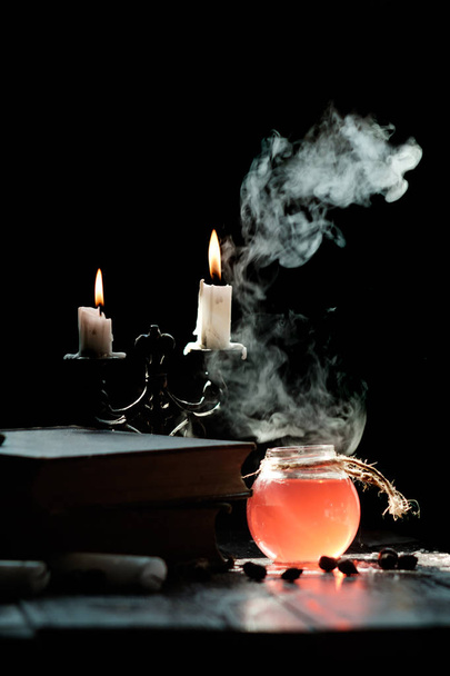 Il concetto di magia e stregoneria. Set di libro di stregoneria, pozione magica e candele sul tavolo. Pozione per la salute. Concetto di alchimia
. - Foto, immagini