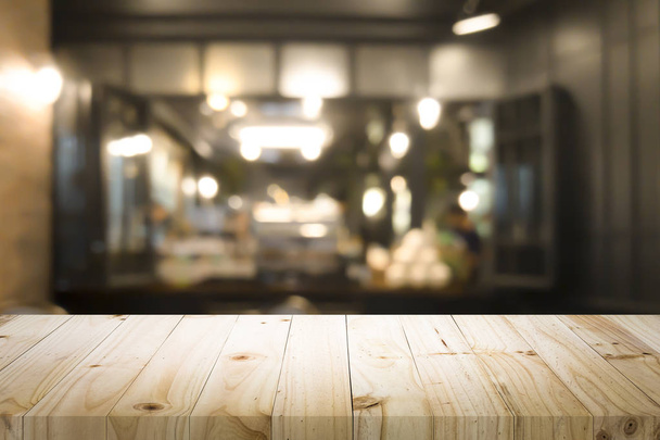 コーヒーショップやソフトドリンクバーで現在の製品のための空の木製テーブルぼかし画像と背景をぼかす - 写真・画像