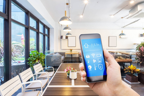 mobiele telefoon met smart home app in de moderne woonkamer - Foto, afbeelding