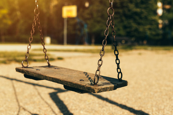 Old abandoned swing on children's playground in the morning - Foto, Imagem