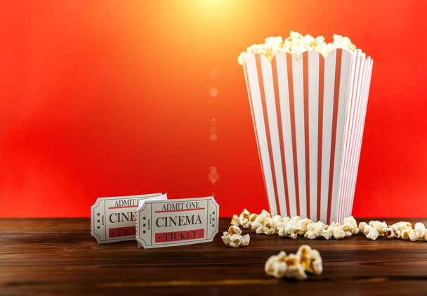 Rote und weiße Eimer Popcorn mit zwei roten Kinokarten. Film-Nacht schließen bis auf rot - Foto, Bild