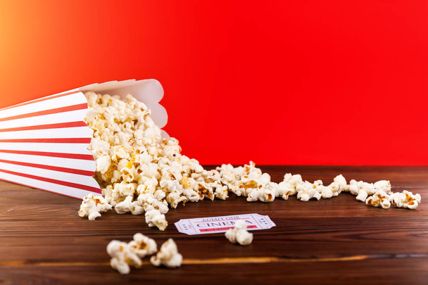 Rote und weiße Eimer Popcorn mit zwei roten Kinokarten. Film-Nacht schließen bis auf rot - Foto, Bild
