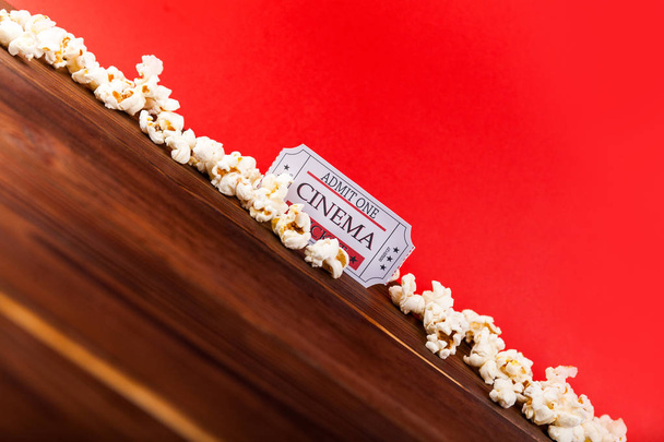 Tło kino. Oglądanie filmu. Popcorn i bilety na miejsca kopiowania drewniane i czerwone tło - Zdjęcie, obraz