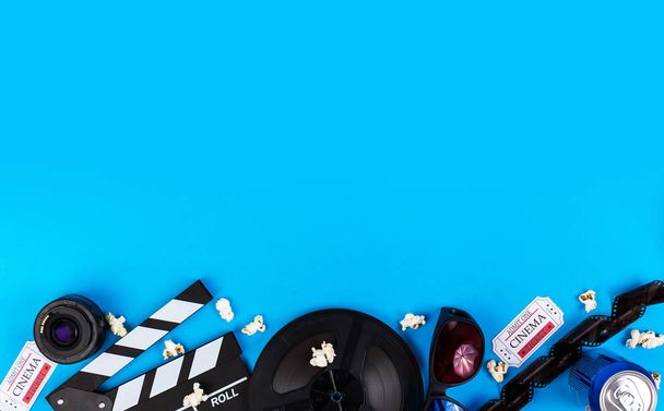 Kino-Film-Hintergrundkamera mit Klappbrett, Eintrittskarten, Brötchen, Gläser Popcorn, Linse, Rolle, Film und Limo - Foto, Bild