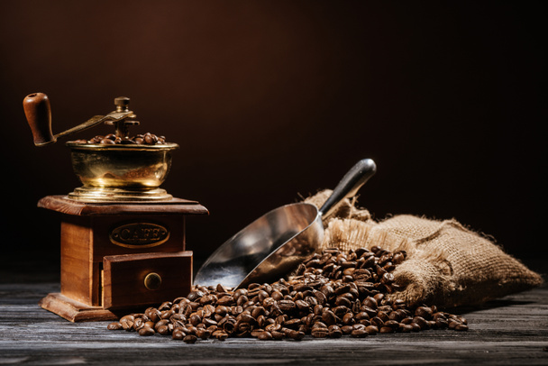 mlýnek na kávu s fazolemi a lopatka na rustikální dřevěný stůl - Fotografie, Obrázek