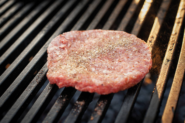 Préparation de côtelettes de bœuf pour les hamburgers sur le gril. De la nourriture. Pique-nique dans la rue
.  - Photo, image