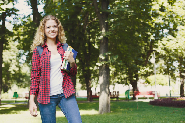 Estudante feminina feliz em pé no parque
 - Foto, Imagem