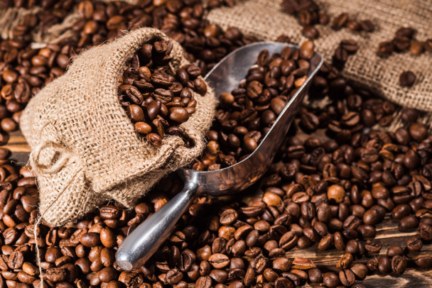 roasted coffee beans with scoop on sackcloth - Фото, зображення