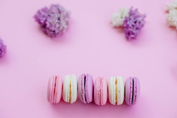 Colored macaroons and lilacs. - Photo, image