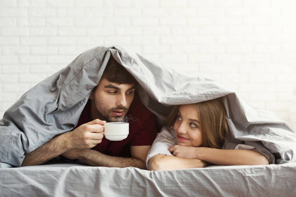 Αγάπη ζευγάρι πίνει καφέ στο κρεβάτι το πρωί - Φωτογραφία, εικόνα