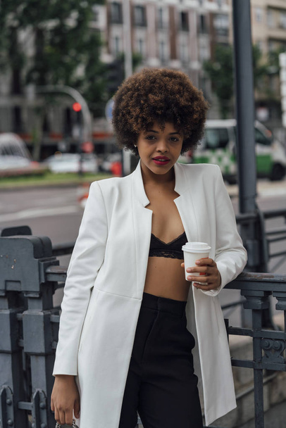 Beautiful Afro hair girl with mobile phone in the streets of Madrid Spain - Fotoğraf, Görsel