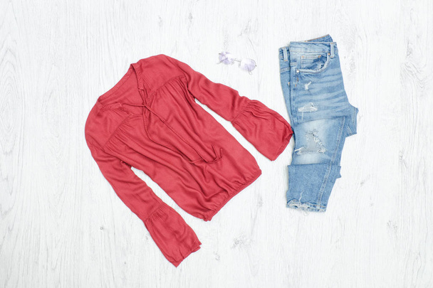 Blusa vermelha, jeans rasgados e óculos de sol. Conceito de moda
 - Foto, Imagem