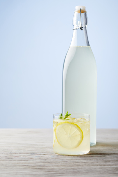 bottle and glass of fresh italian limoncello on wooden surface - 写真・画像