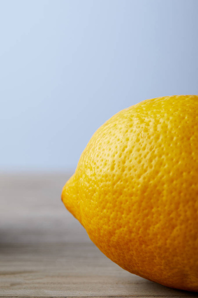 close-up shot of ripe lemon on wooden surface - Фото, изображение