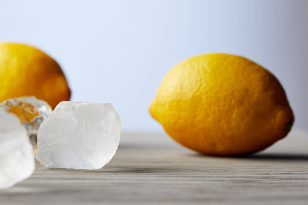 close-up shot of lemons and ice cubes on wooden surface - 写真・画像